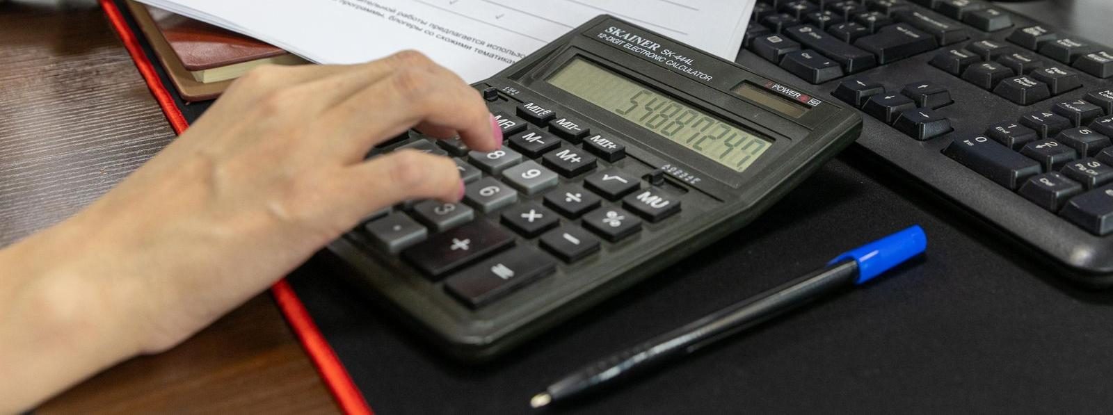 Calcolatrice e documento sulla scrivania per controllare i ricavi incassati del forfettario