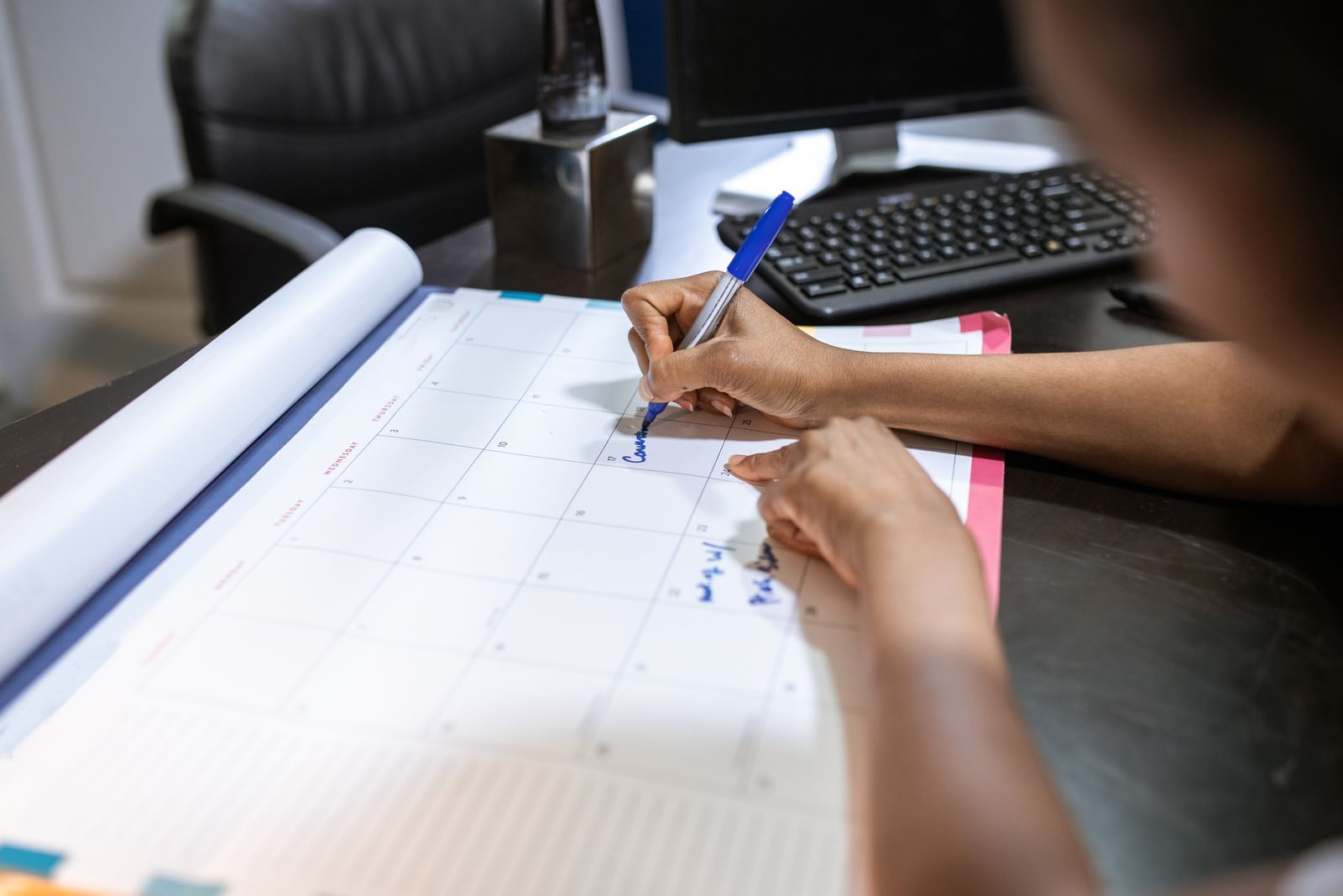 Persona che segna una scadenza su un calendario da scrivania
