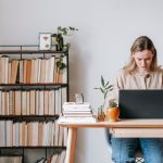 Libero professionista al computer portatile alla scrivania di casa